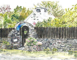 Stone archway with blue accent and pink flowers in front of a fence and white house with sun motif.